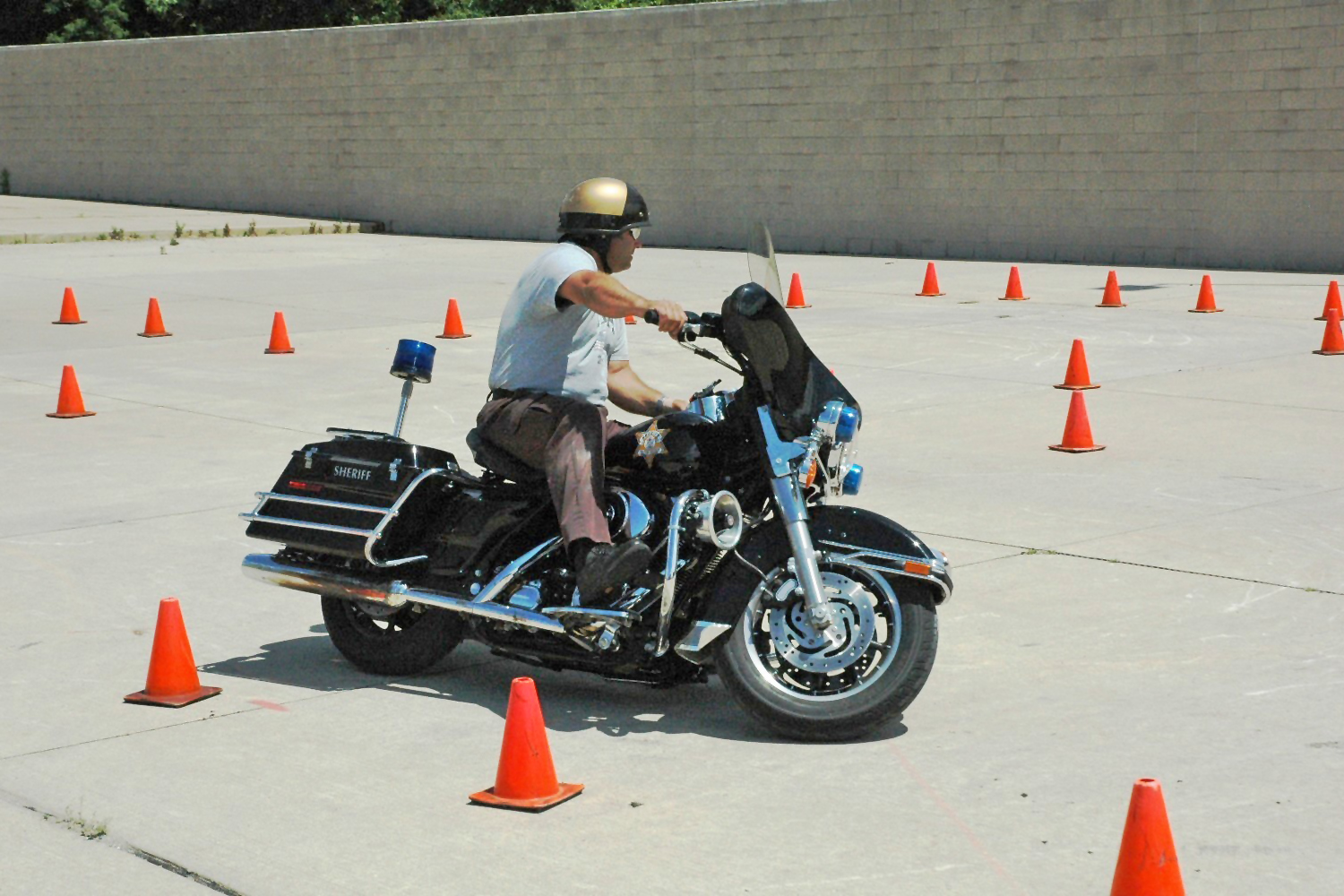 Law enforcement officer maneuvering motorcycle through course  