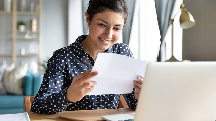 student with paper and laptop